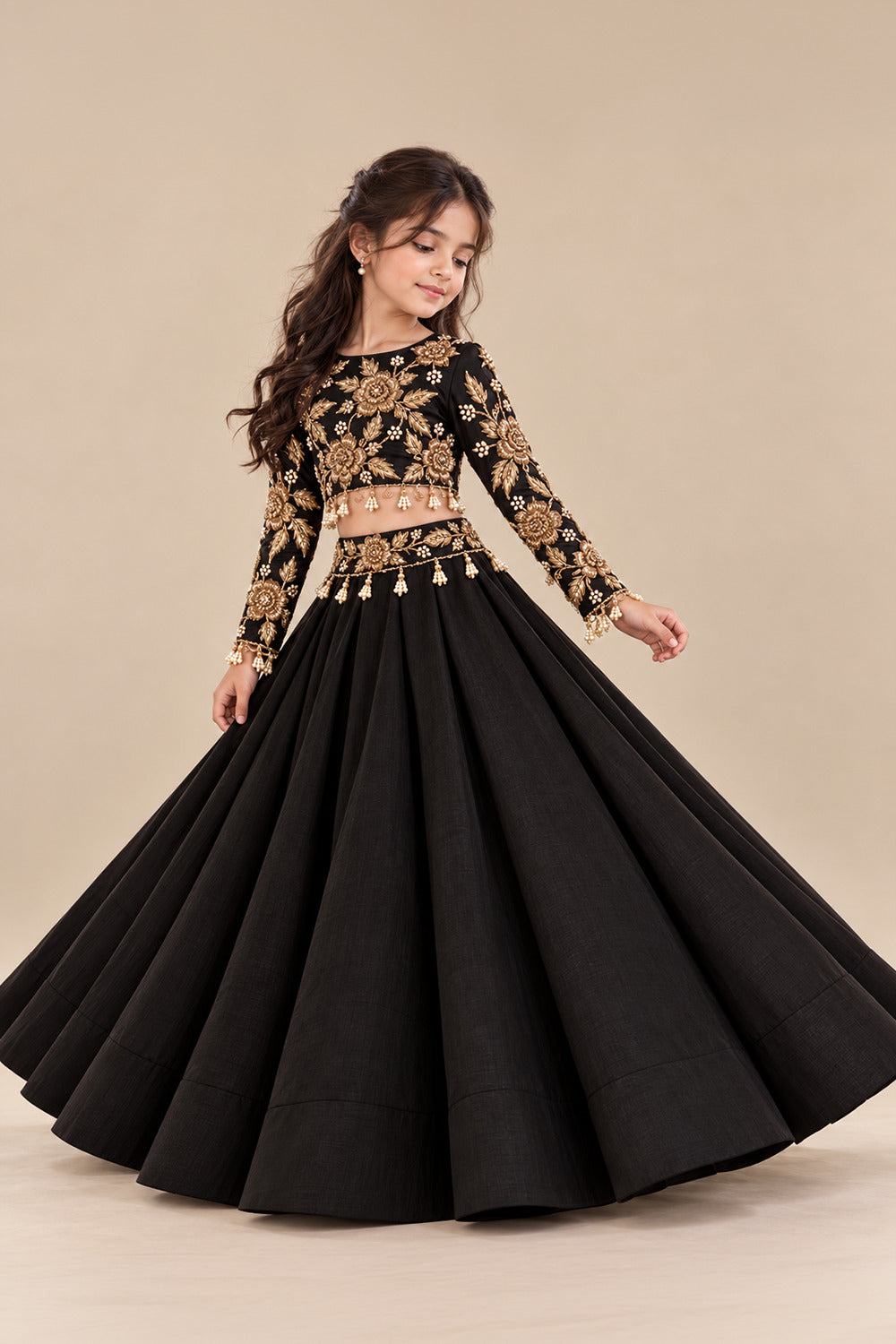 A Luxurious Black Lehenga Set Featuring A Full Sleeved Blouse With Golden Embroidery And Pearl Tassels Paired With Flared Lehenga