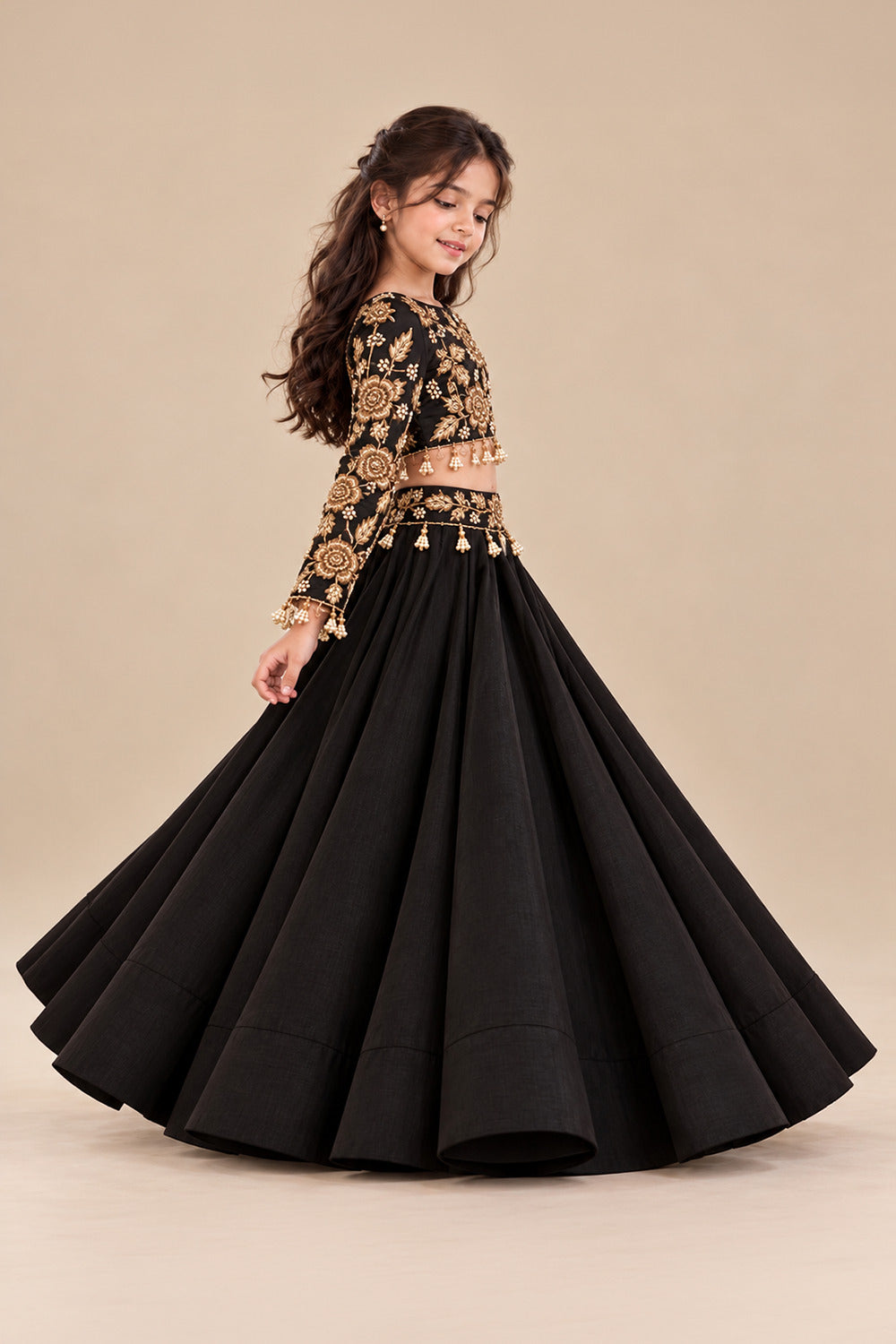 A Luxurious Black Lehenga Set Featuring A Full Sleeved Blouse With Golden Embroidery And Pearl Tassels Paired With Flared Lehenga