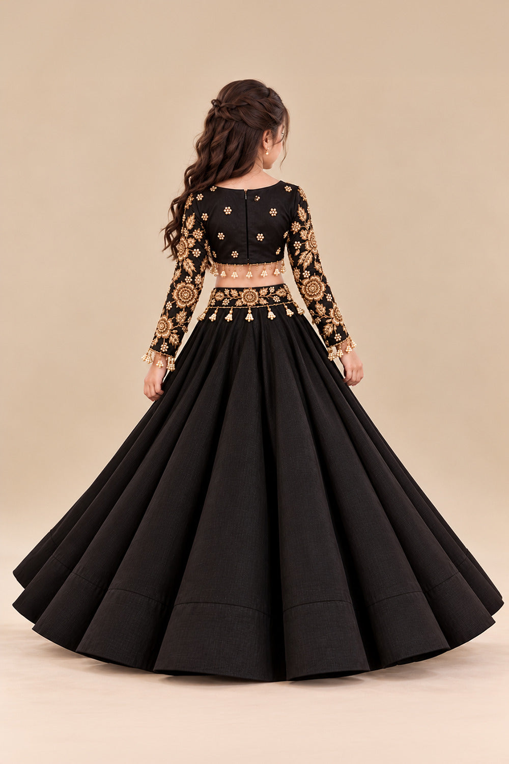 A Luxurious Black Lehenga Set Featuring A Full Sleeved Blouse With Golden Embroidery And Pearl Tassels Paired With Flared Lehenga